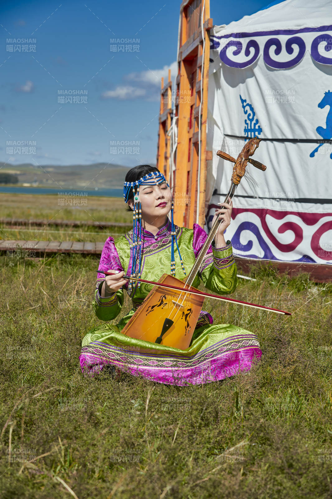 蒙古包前穿蒙古族服飾拉馬頭琴的蒙族女樂手