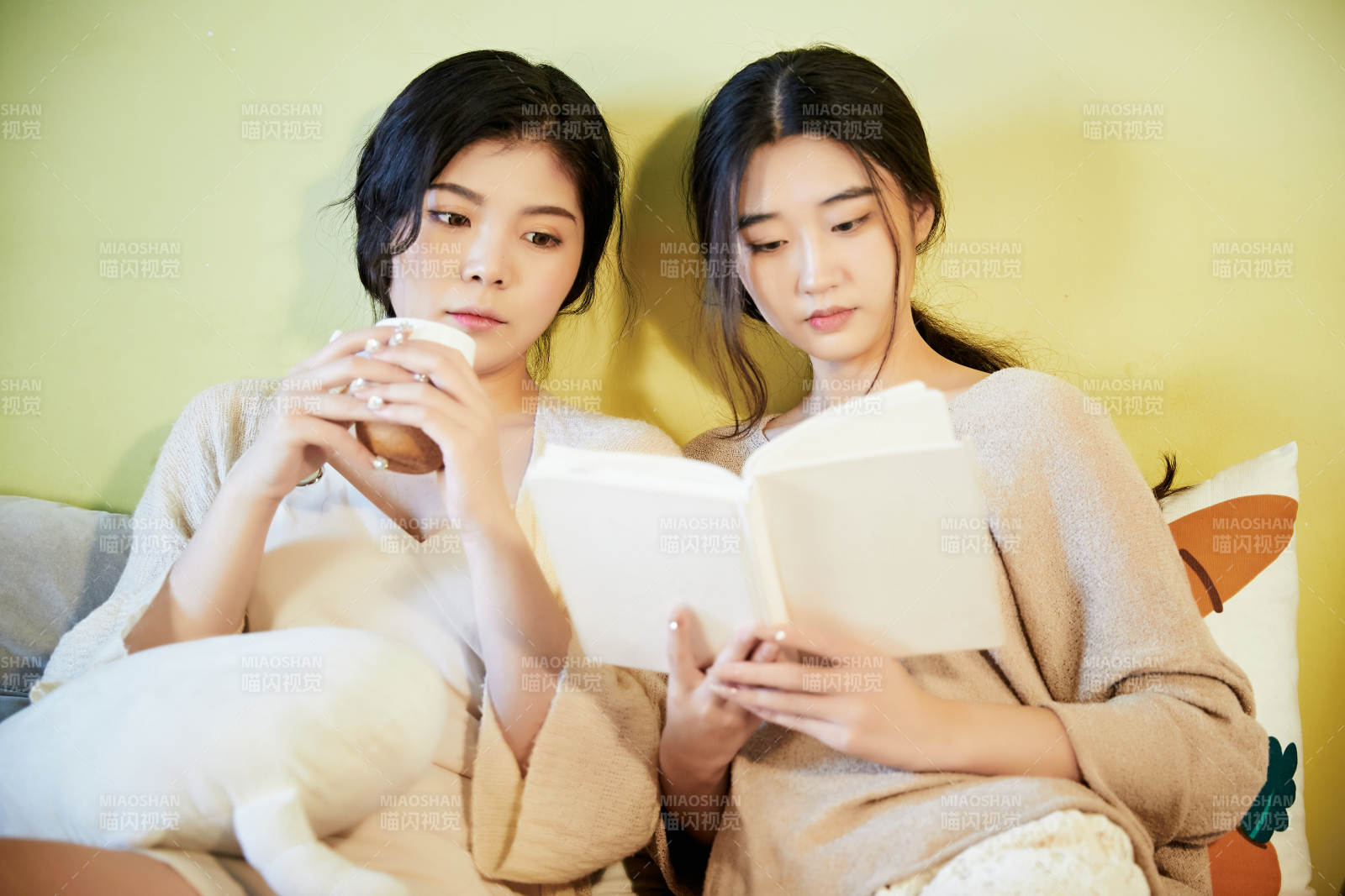 坐在床上讀書的倆位美女