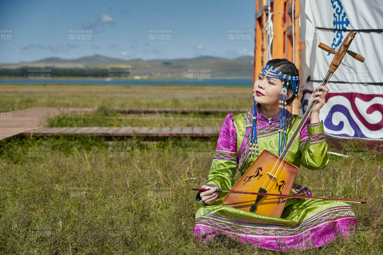 蒙古包前穿蒙古族服飾拉馬頭琴的蒙族女樂手