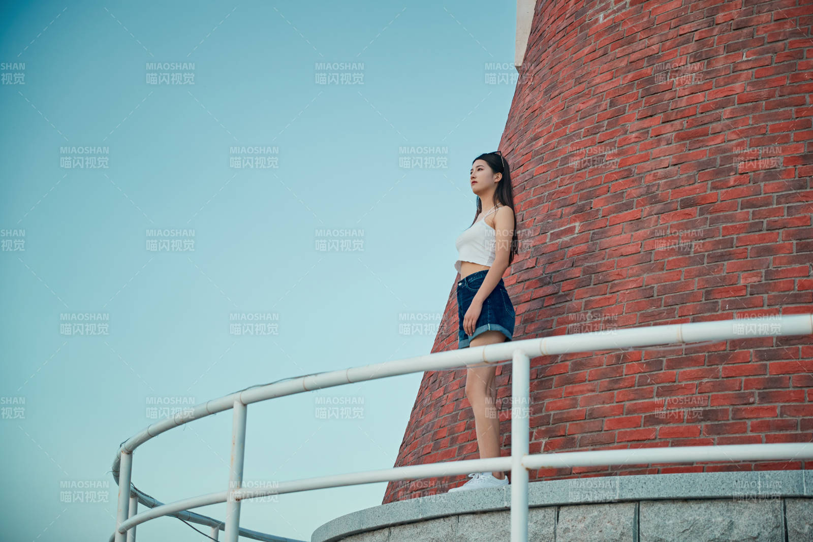 盛夏夕陽晚霞湖邊碼頭看風景的少女