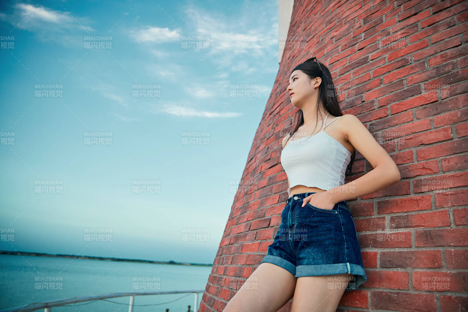 盛夏夕陽晚霞湖邊碼頭看風景的少女