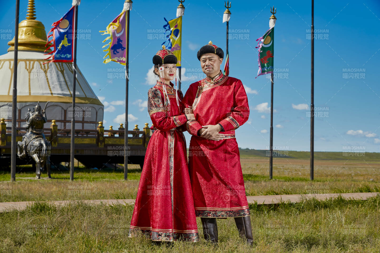 草原上蒙古包前穿蒙古族傳統服飾的年輕夫妻