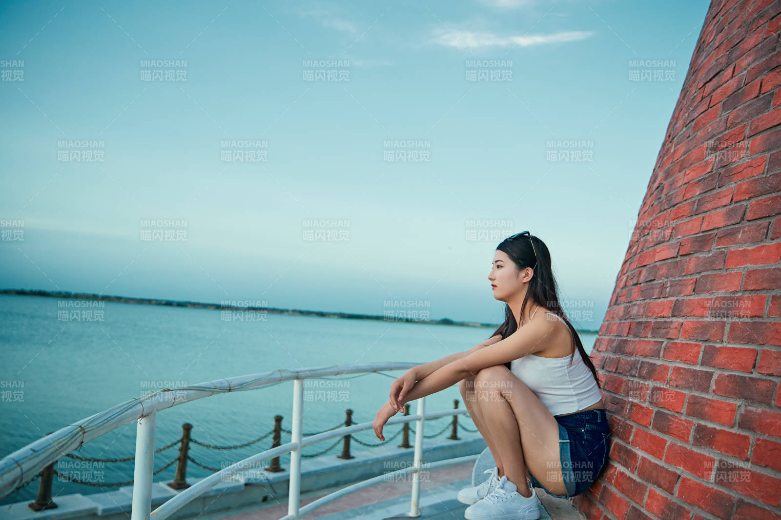 盛夏夕陽晚霞湖邊碼頭看風景的少女