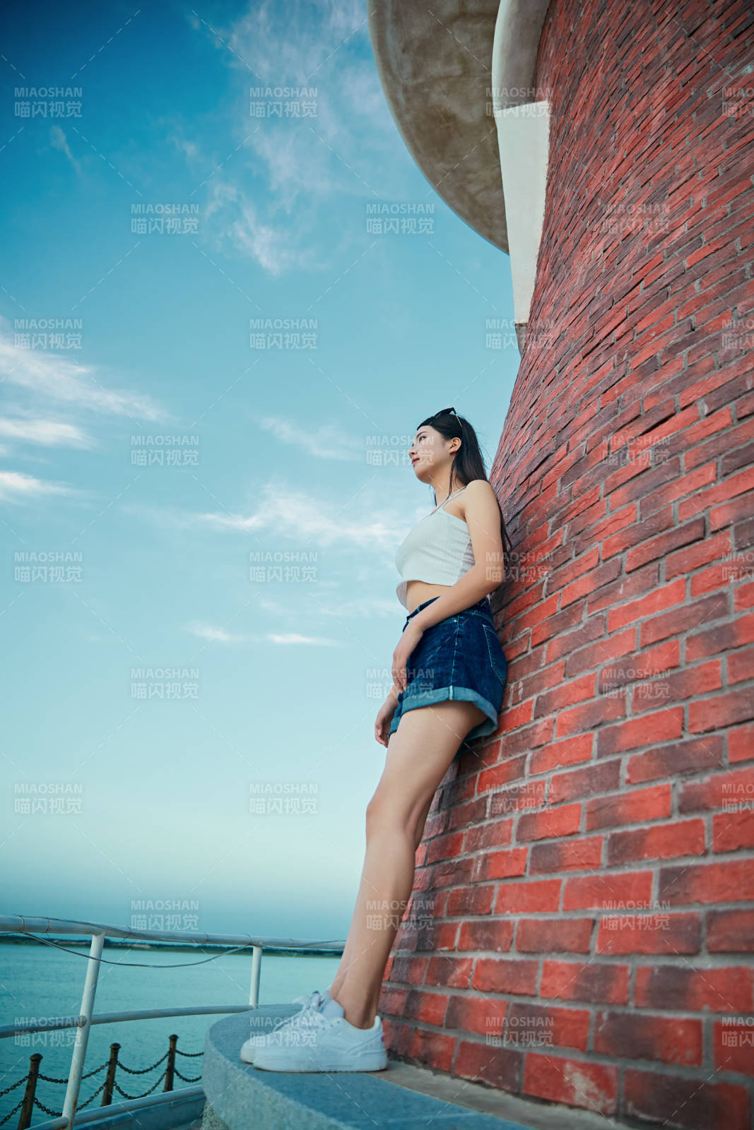 盛夏夕陽晚霞湖邊碼頭看風景的少女
