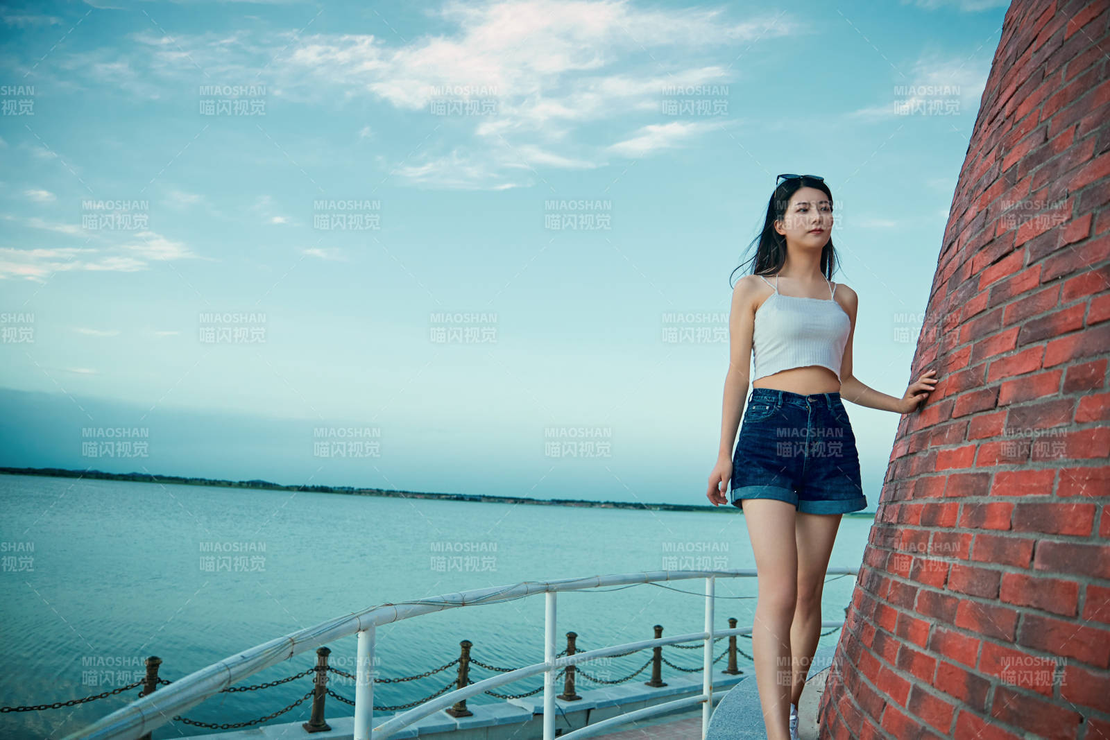 盛夏夕陽晚霞湖邊碼頭看風景的少女