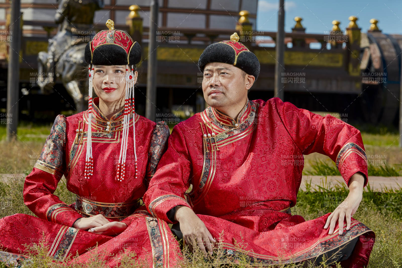 草原上蒙古包前穿蒙古族傳統服飾的年輕夫妻