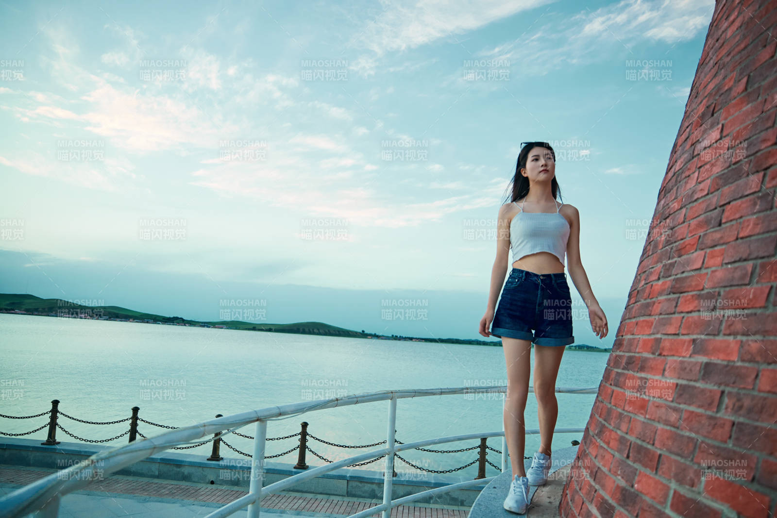 盛夏夕陽晚霞湖邊碼頭看風景的少女