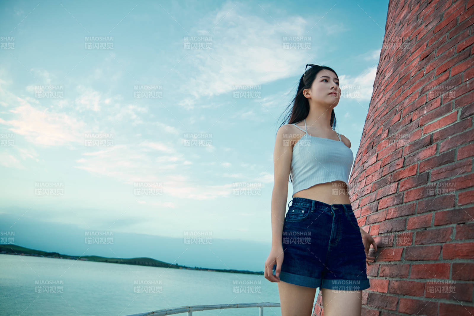 盛夏夕陽晚霞湖邊碼頭看風景的少女