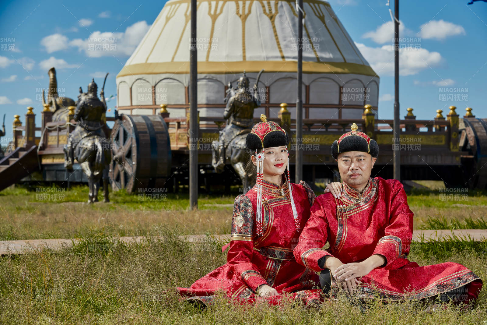 草原上蒙古包前穿蒙古族傳統服飾的年輕夫妻
