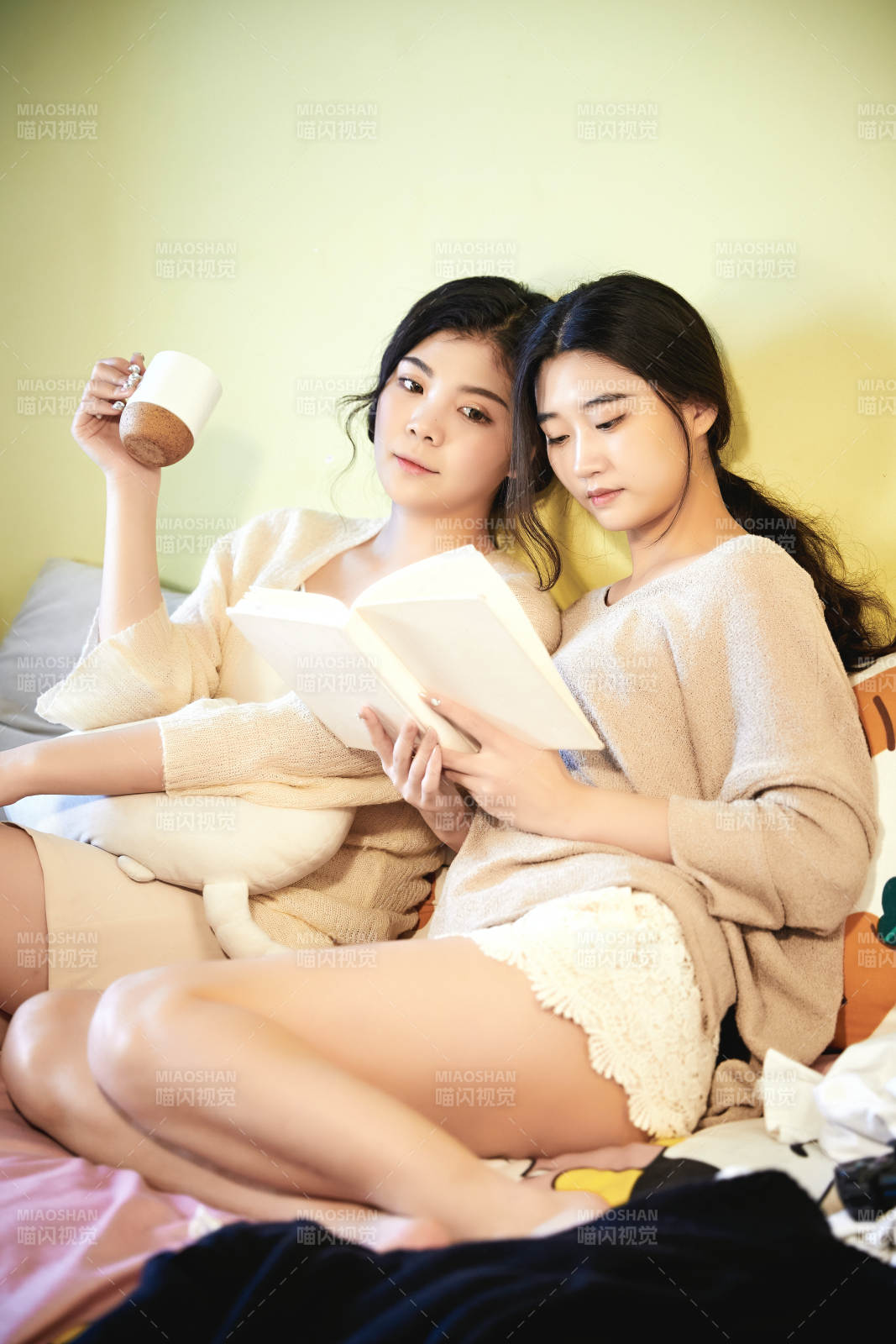 坐在床上讀書的倆位美女