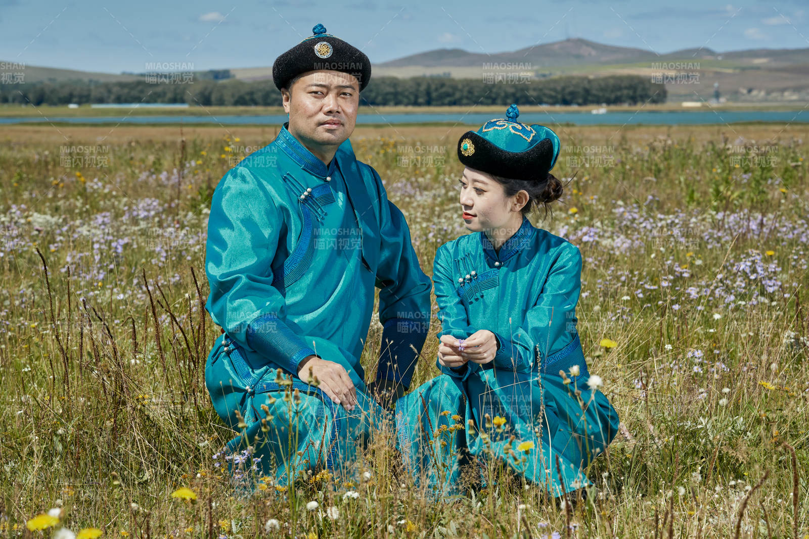 草原上蒙古包前穿蒙古族傳統服飾的年輕夫妻