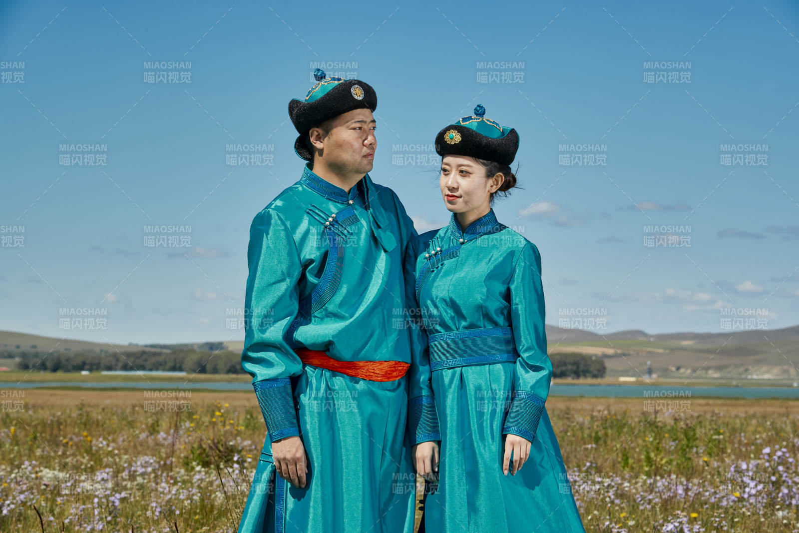 草原上蒙古包前穿蒙古族傳統服飾的年輕夫妻