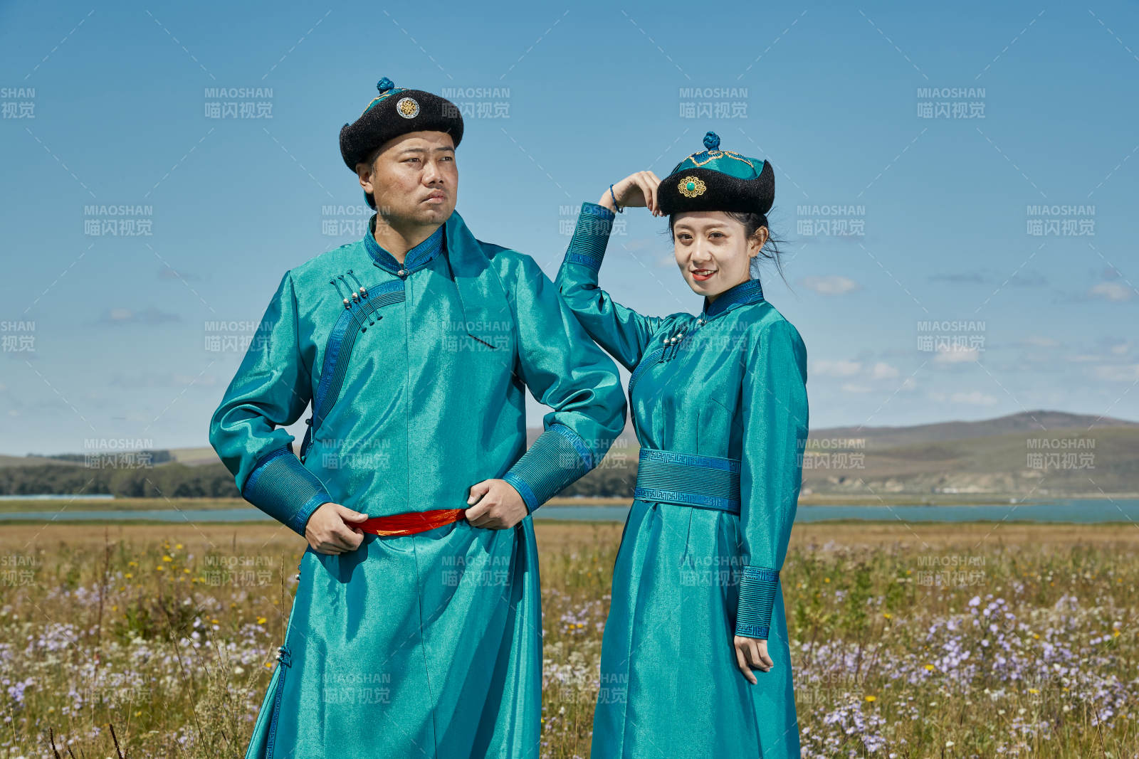 草原上蒙古包前穿蒙古族傳統服飾的年輕夫妻