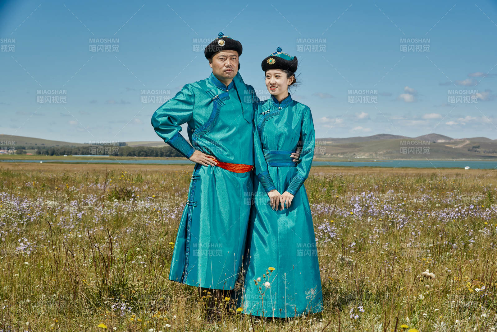 草原上蒙古包前穿蒙古族傳統(tǒng)服飾的年輕夫妻