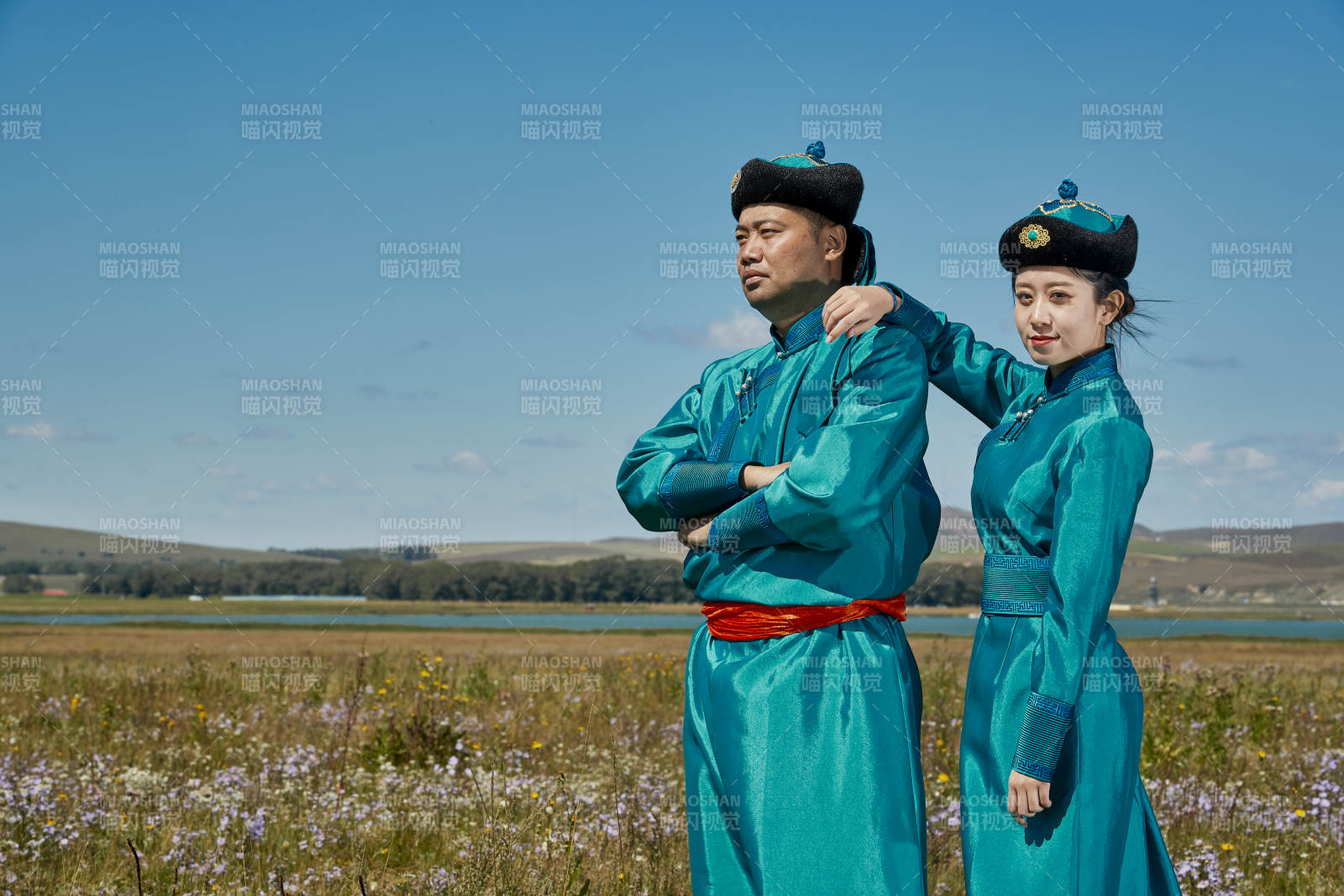 草原上蒙古包前穿蒙古族傳統服飾的年輕夫妻