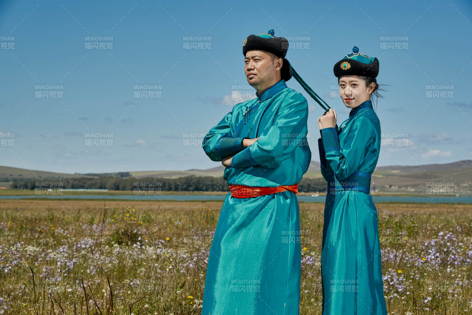 草原上蒙古包前穿蒙古族傳統服飾的年輕夫妻