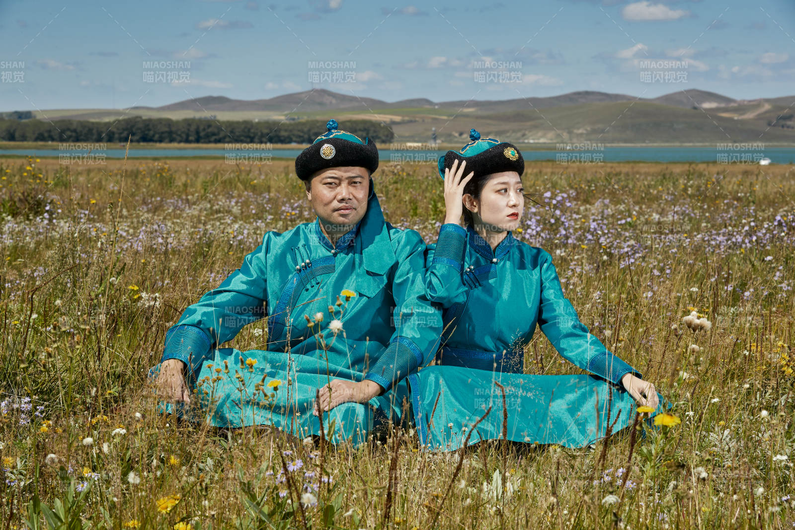 草原上蒙古包前穿蒙古族傳統服飾的年輕夫妻