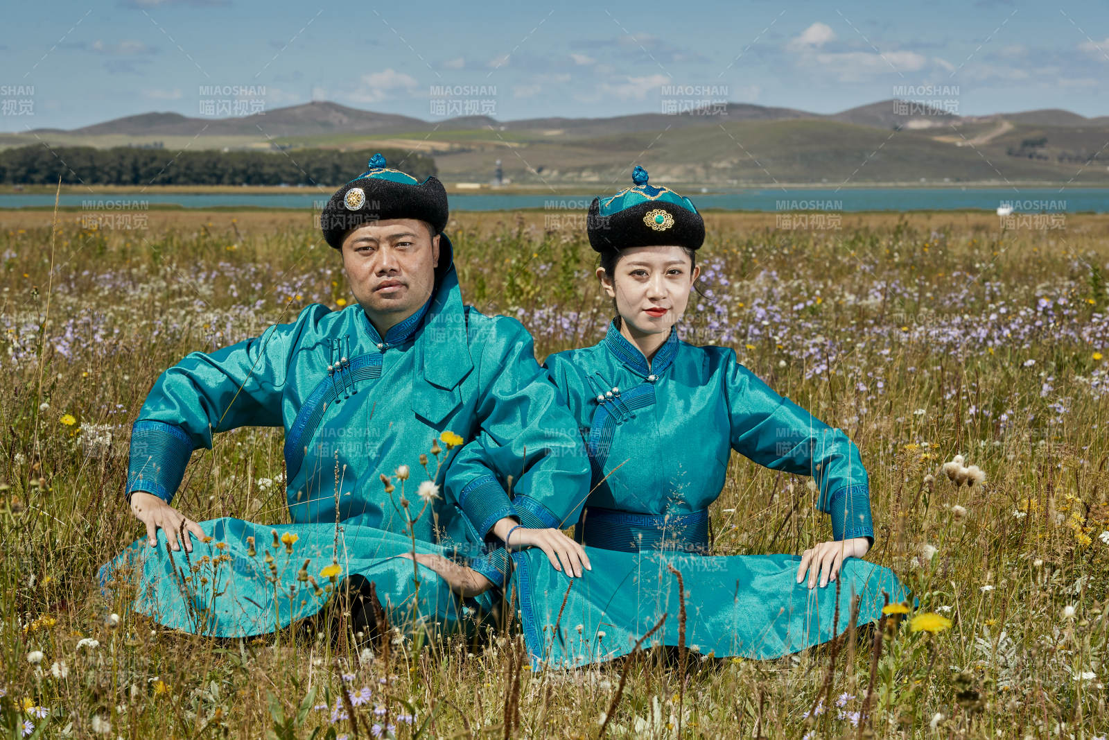 草原上蒙古包前穿蒙古族傳統服飾的年輕夫妻