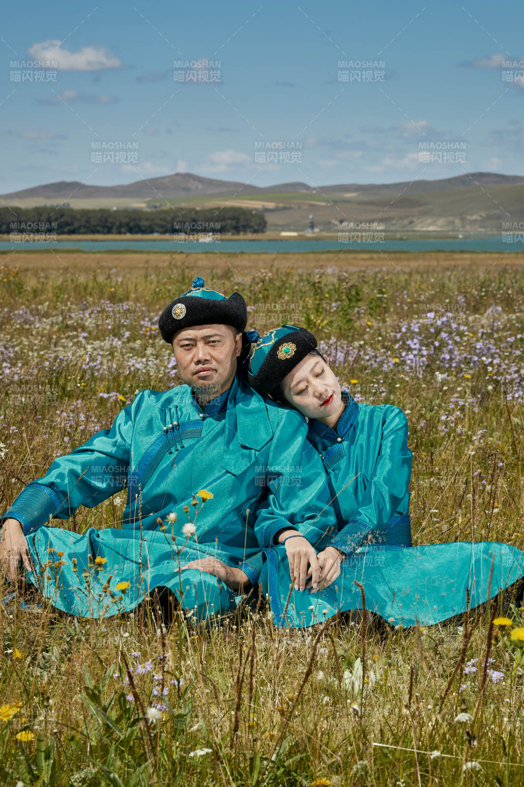 草原上蒙古包前穿蒙古族傳統(tǒng)服飾的年輕夫妻