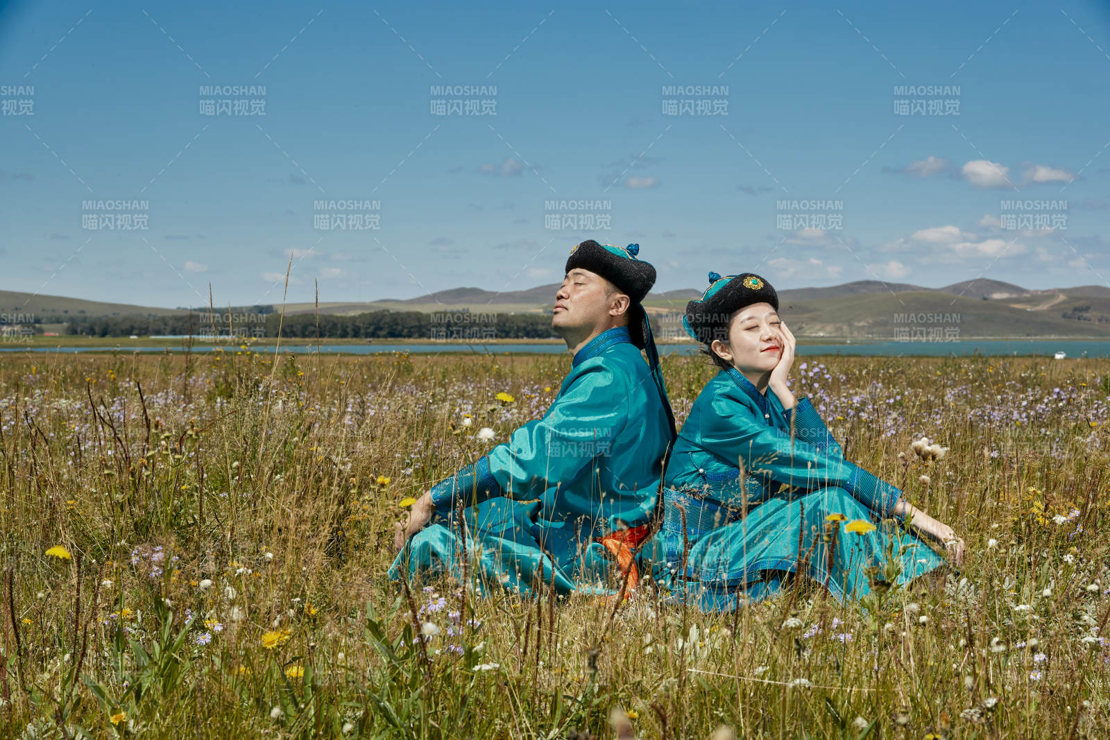 草原上蒙古包前穿蒙古族傳統服飾的年輕夫妻