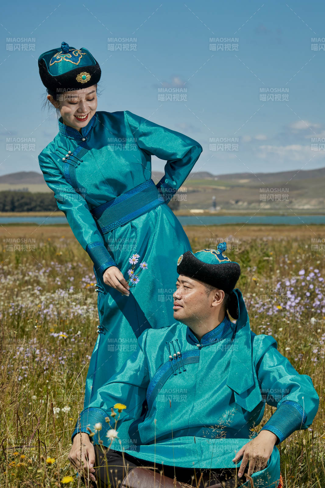 草原上蒙古包前穿蒙古族傳統服飾的年輕夫妻