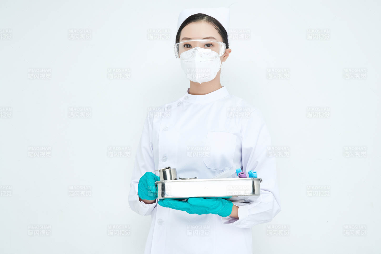 身穿護士服手抱化驗托盤的年輕女護士