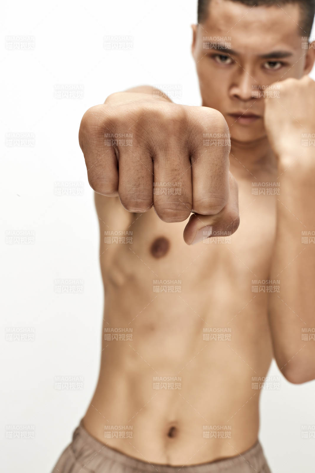 白色背景下演示自由搏擊動作的亞洲功夫男性