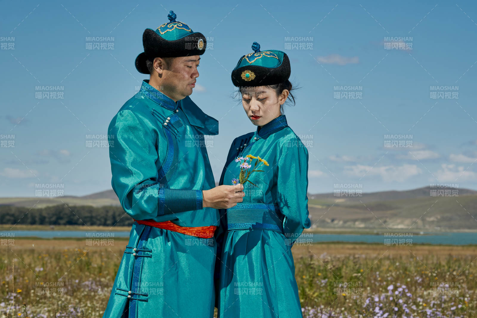 草原上蒙古包前穿蒙古族傳統服飾的年輕夫妻