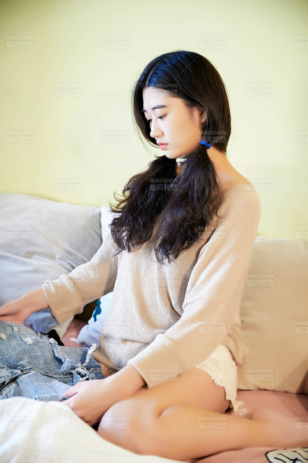 在沙發床上整理行裝的年輕亞洲女性