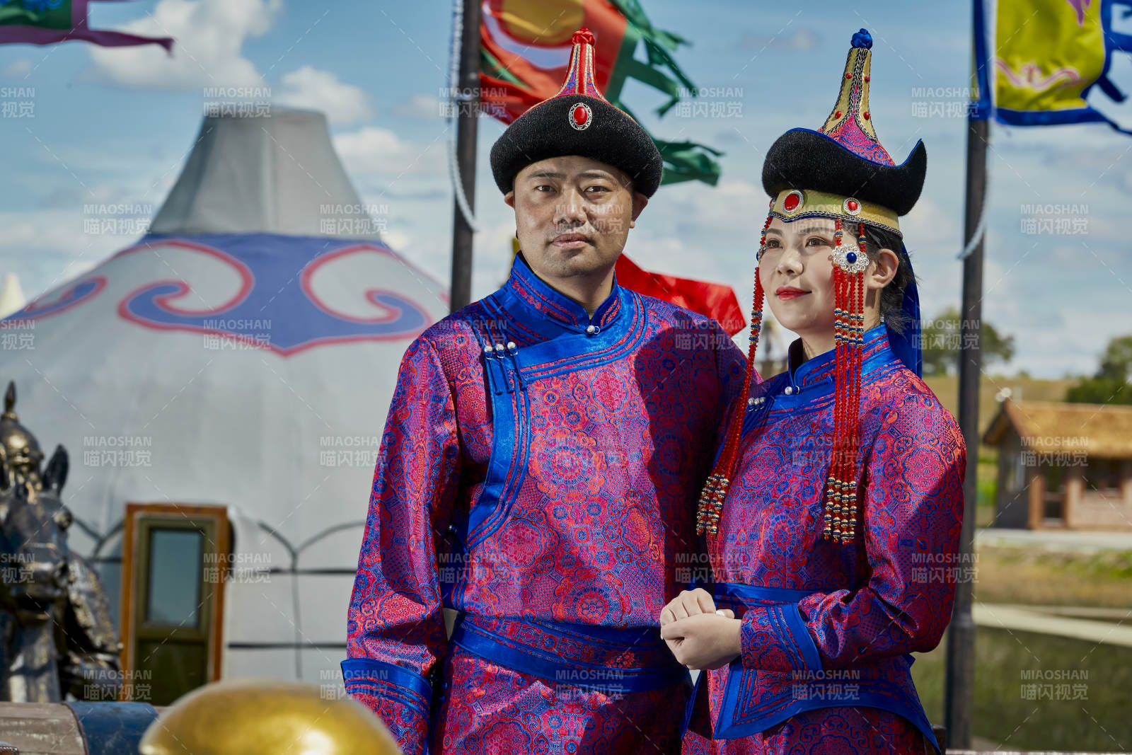 草原上蒙古包前穿蒙古族傳統(tǒng)服飾的年輕夫妻