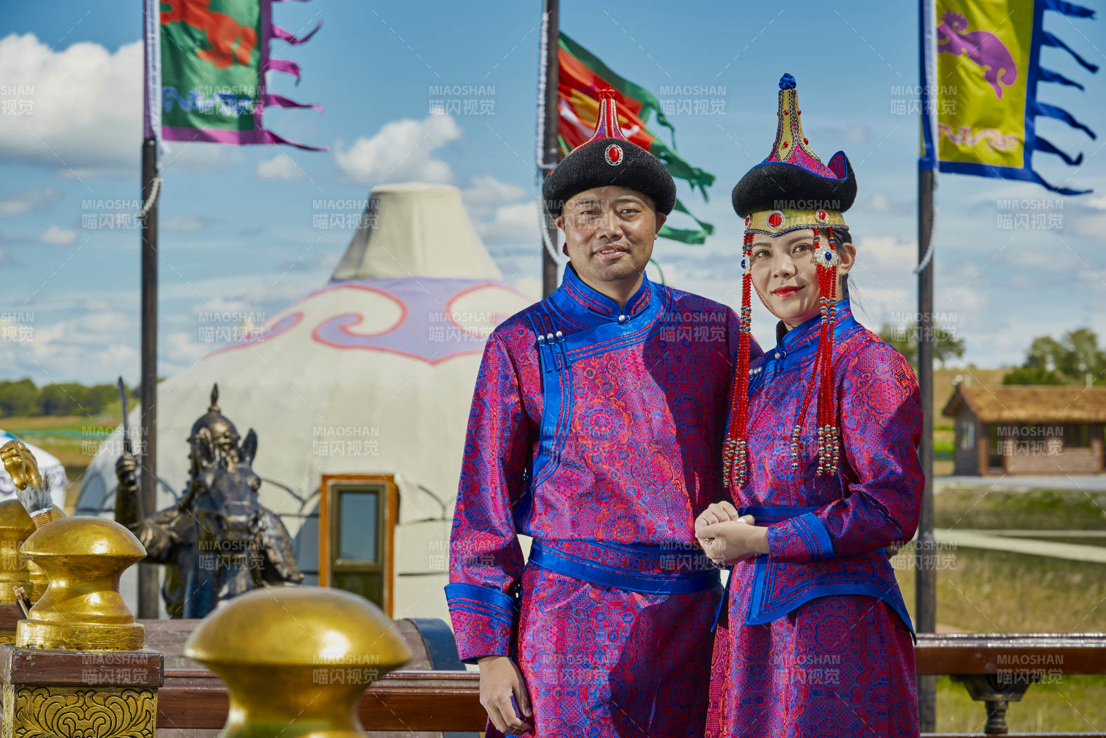 草原上蒙古包前穿蒙古族傳統服飾的年輕夫妻