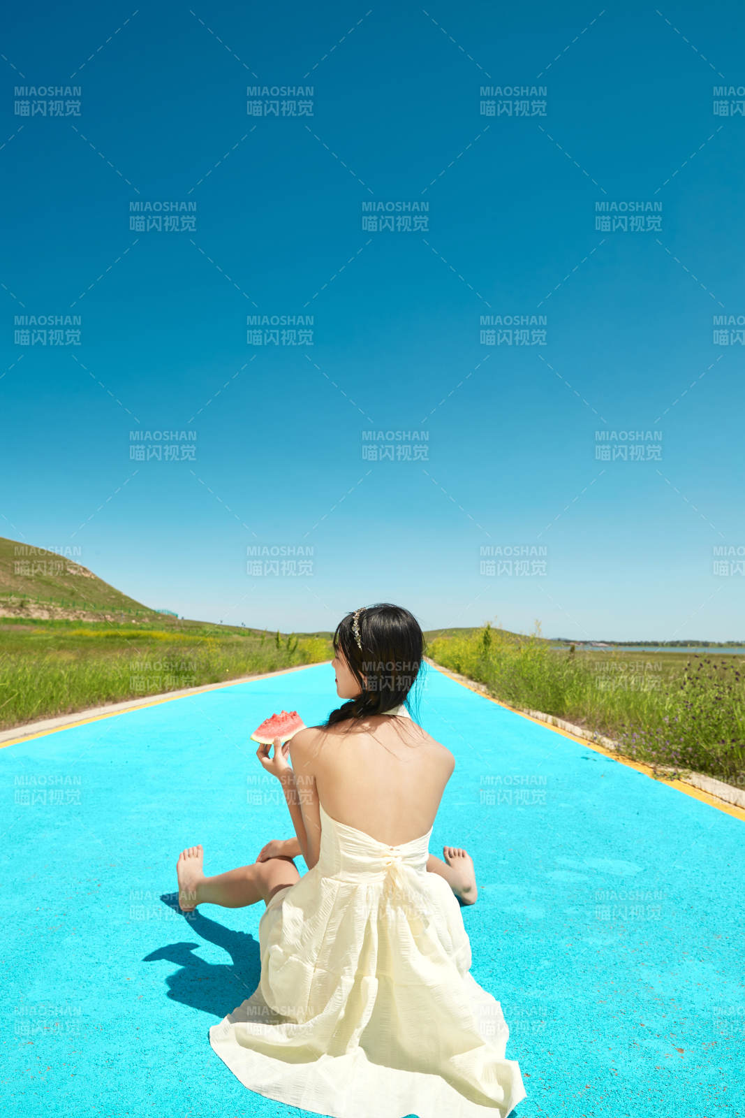 夏日戶外湖邊彩色公路上玩耍吃西瓜的少女