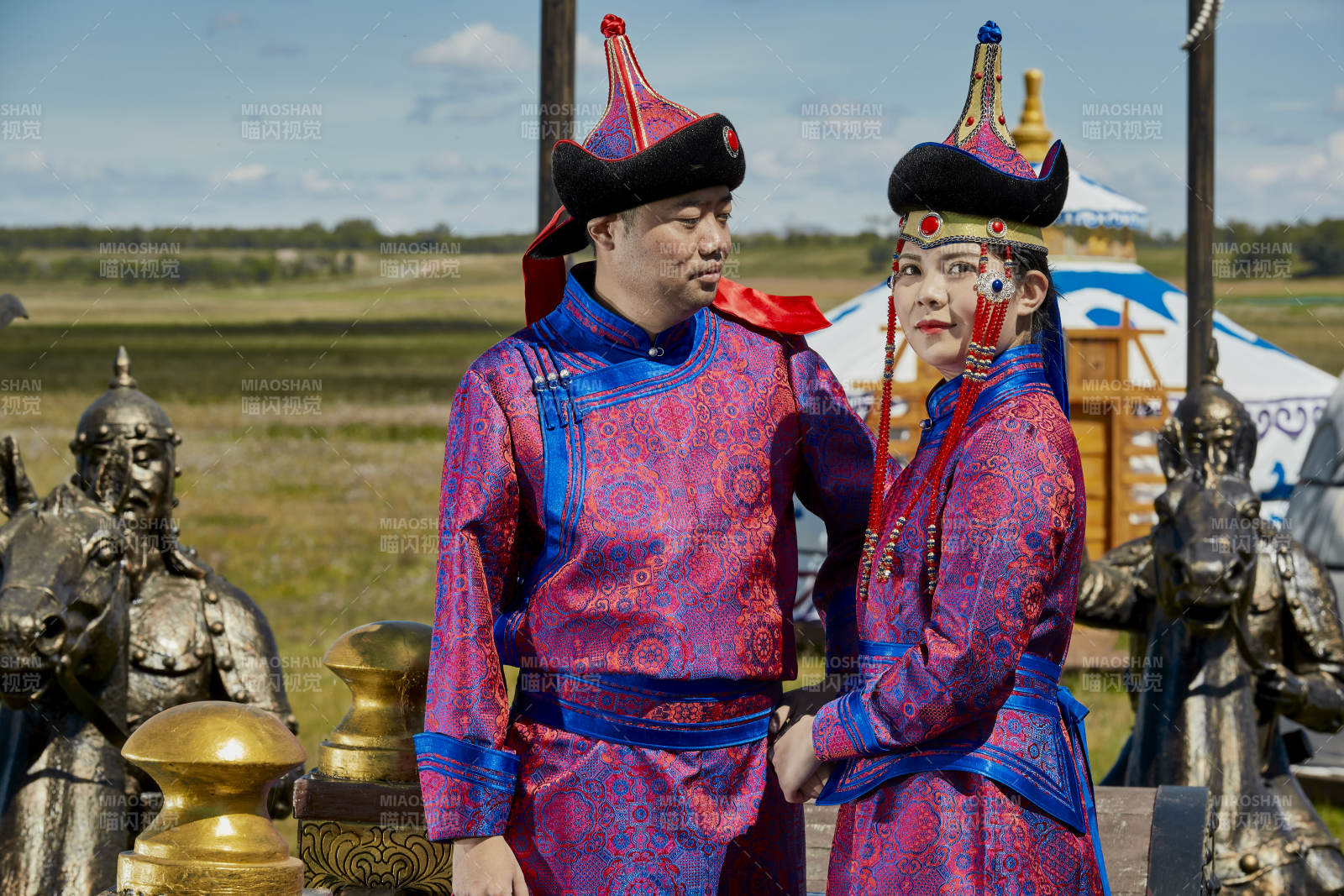草原上蒙古包前穿蒙古族傳統服飾的年輕夫妻
