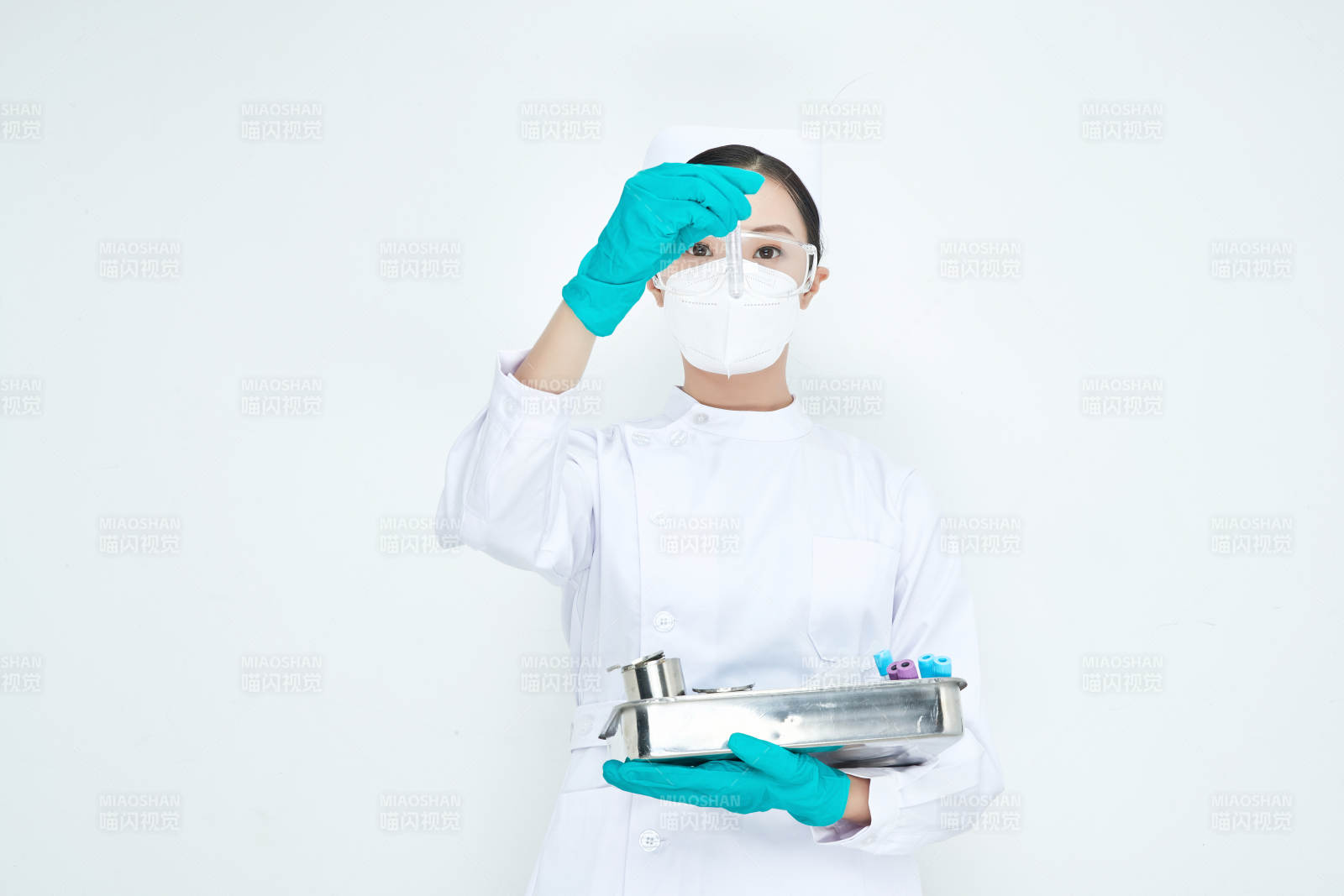 身穿護士服手抱化驗托盤的年輕女護士