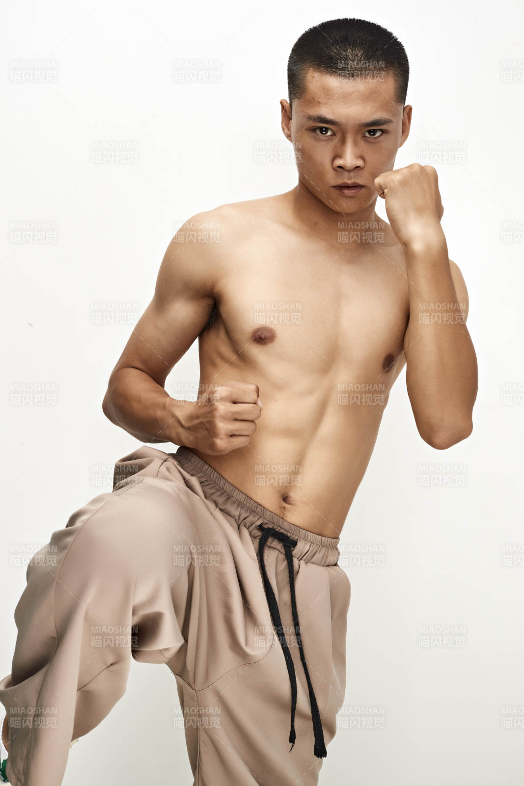 白色背景下演示自由搏擊動作的亞洲功夫男性