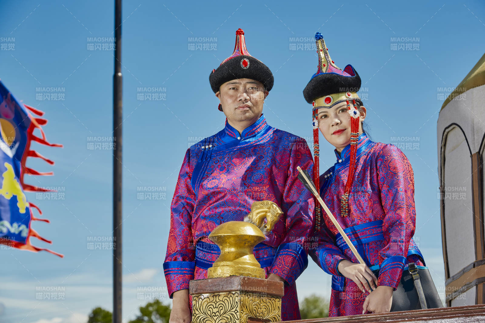 草原上蒙古包前穿蒙古族傳統服飾的年輕夫妻