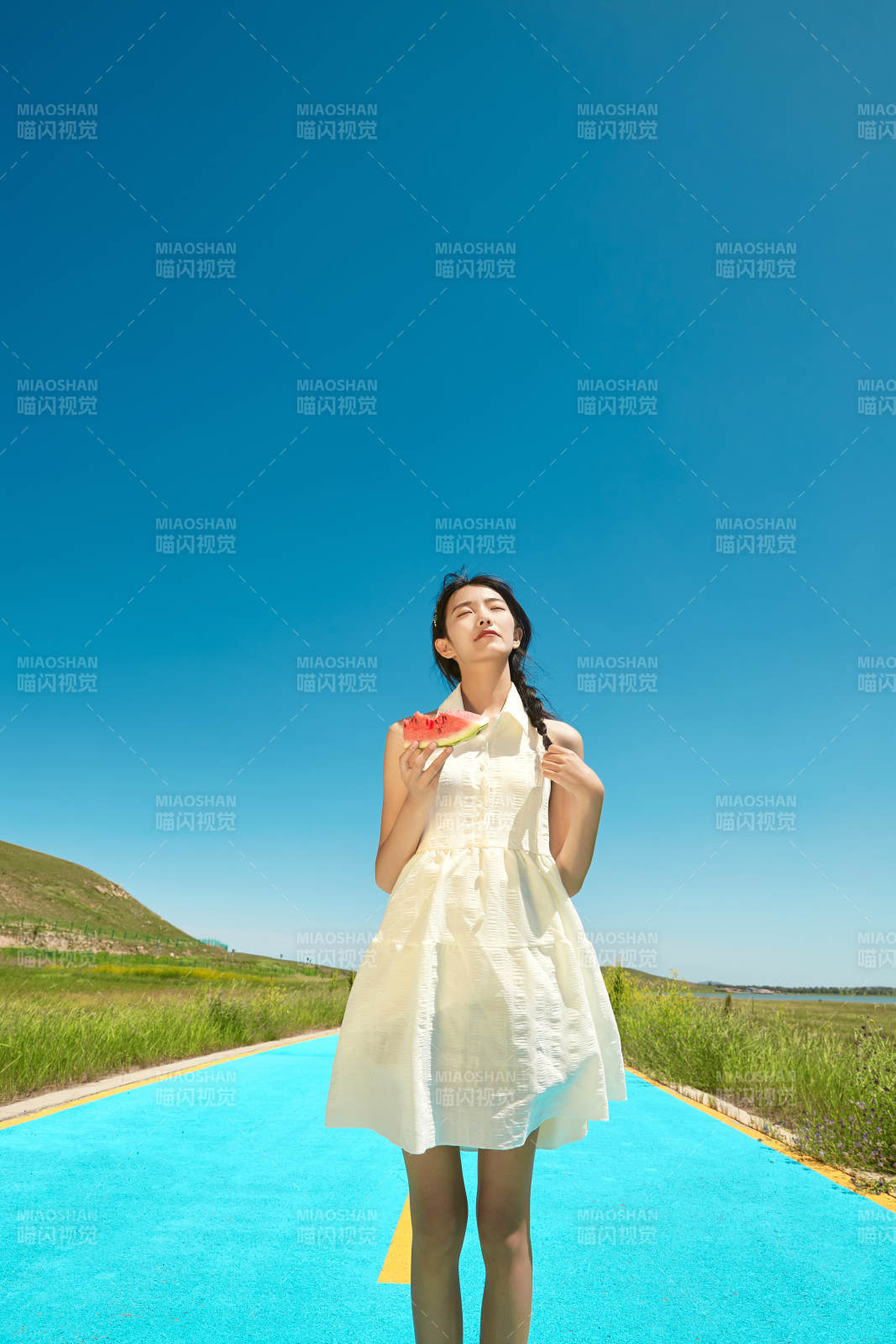 夏日戶外湖邊彩色公路上玩耍吃西瓜的少女