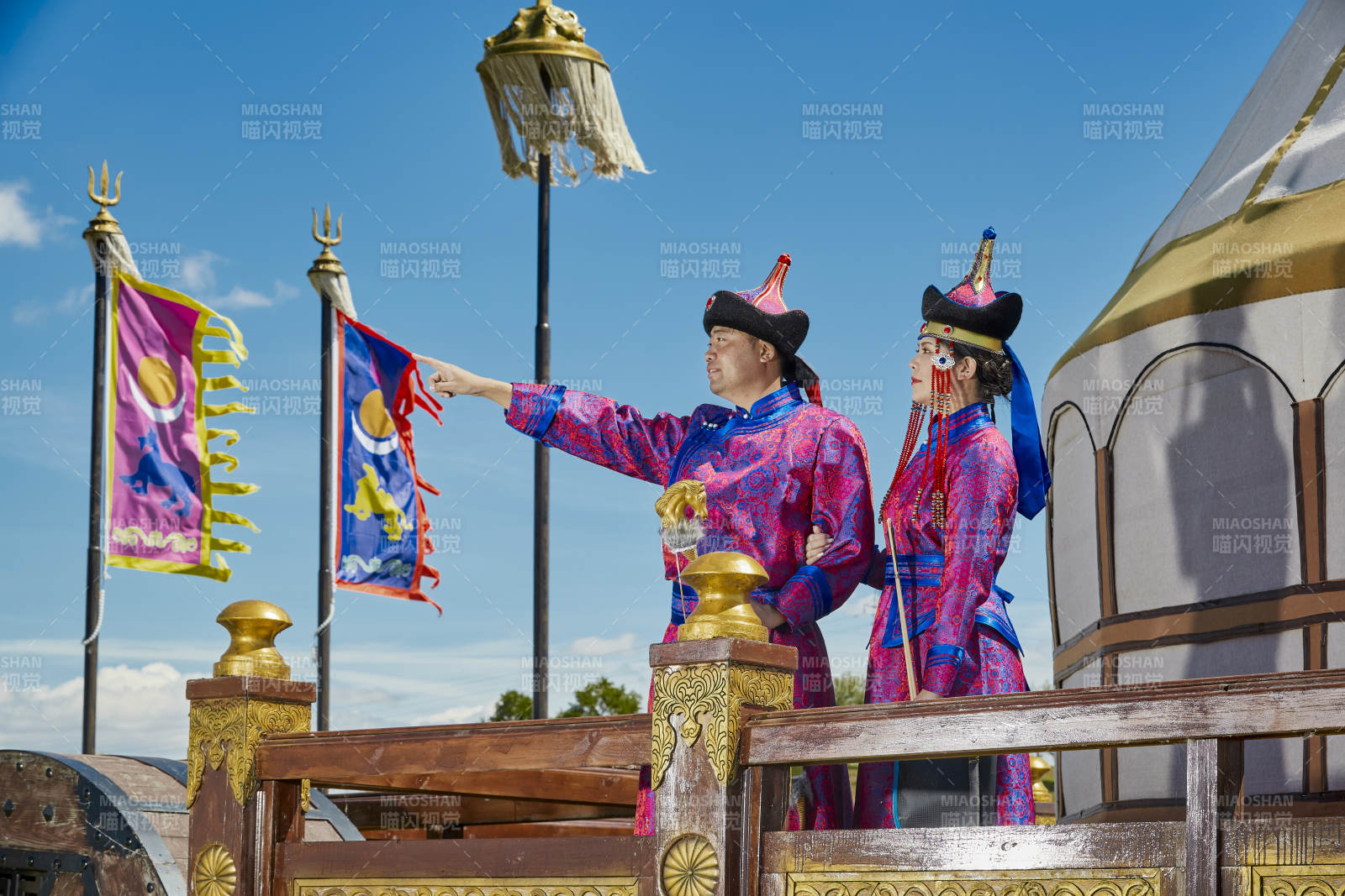 草原上蒙古包前穿蒙古族傳統服飾的年輕夫妻