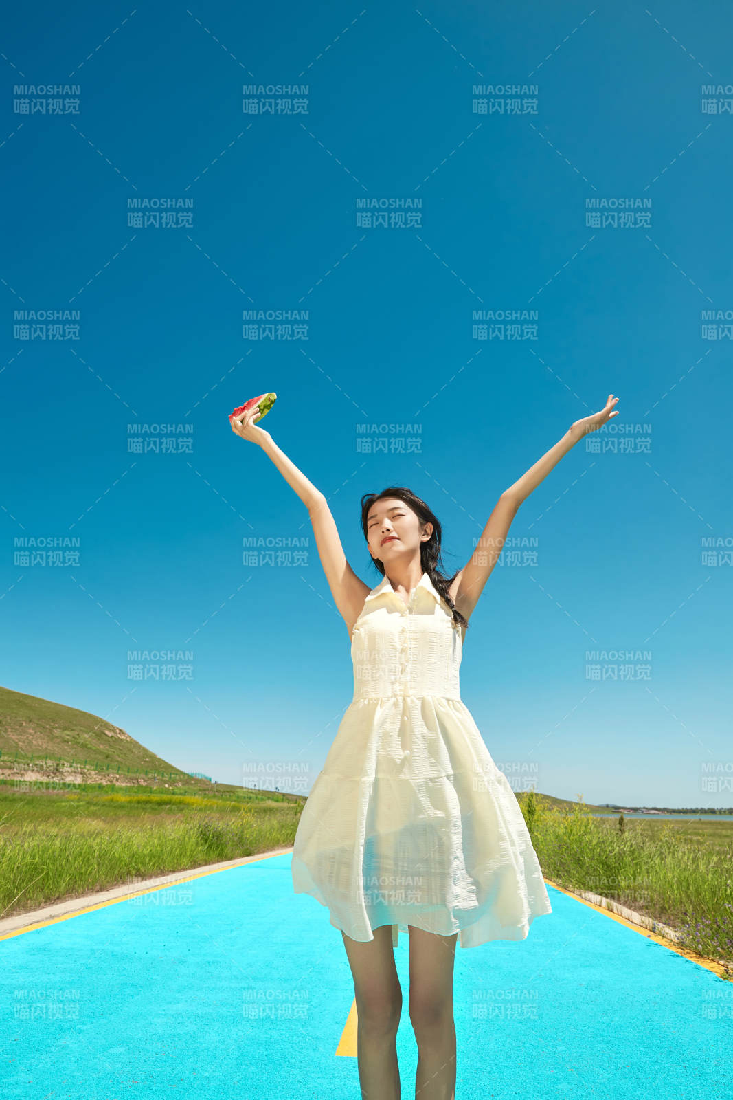 夏日戶外湖邊彩色公路上玩耍吃西瓜的少女