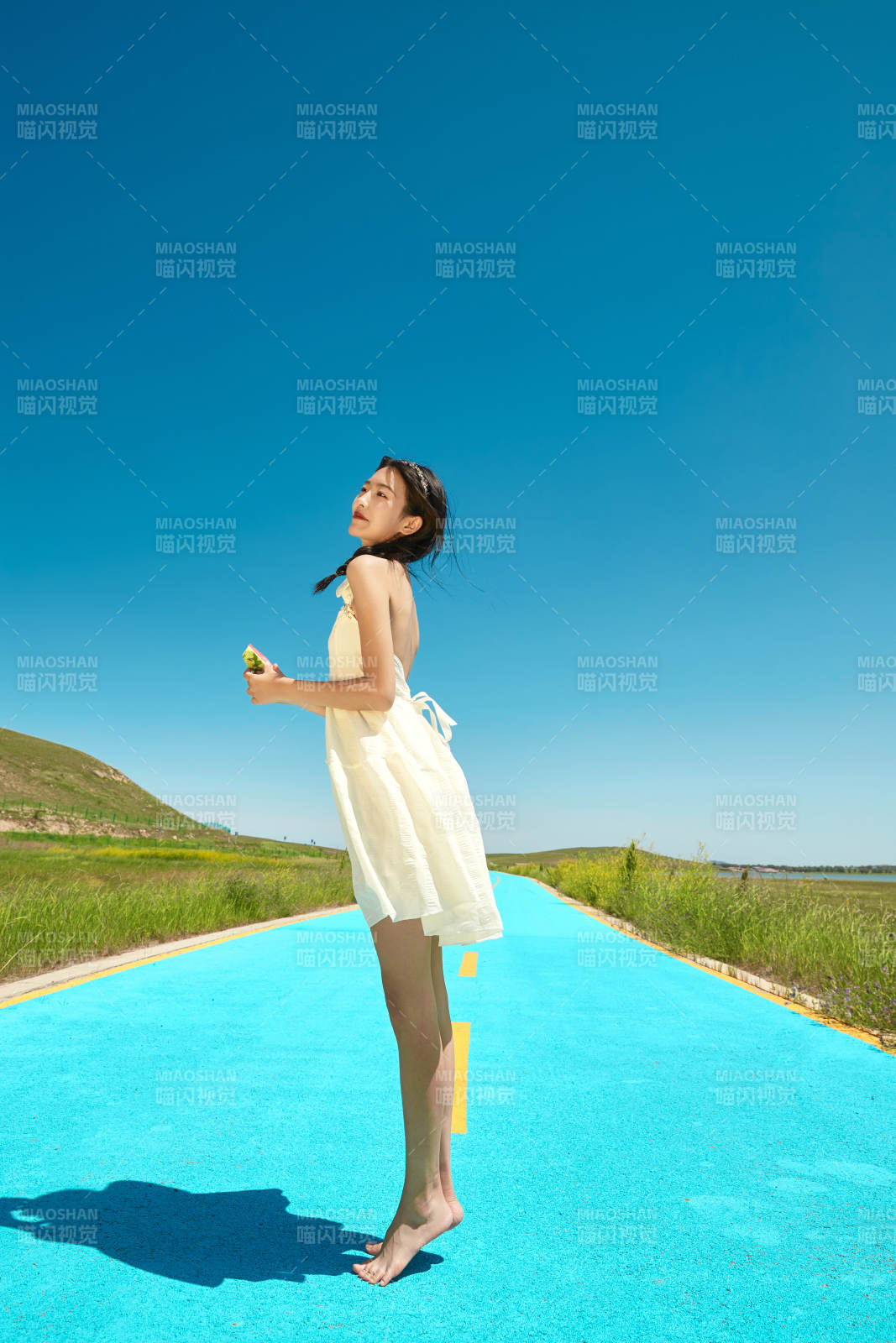 夏日户外湖边彩色公路上玩耍吃西瓜的少女