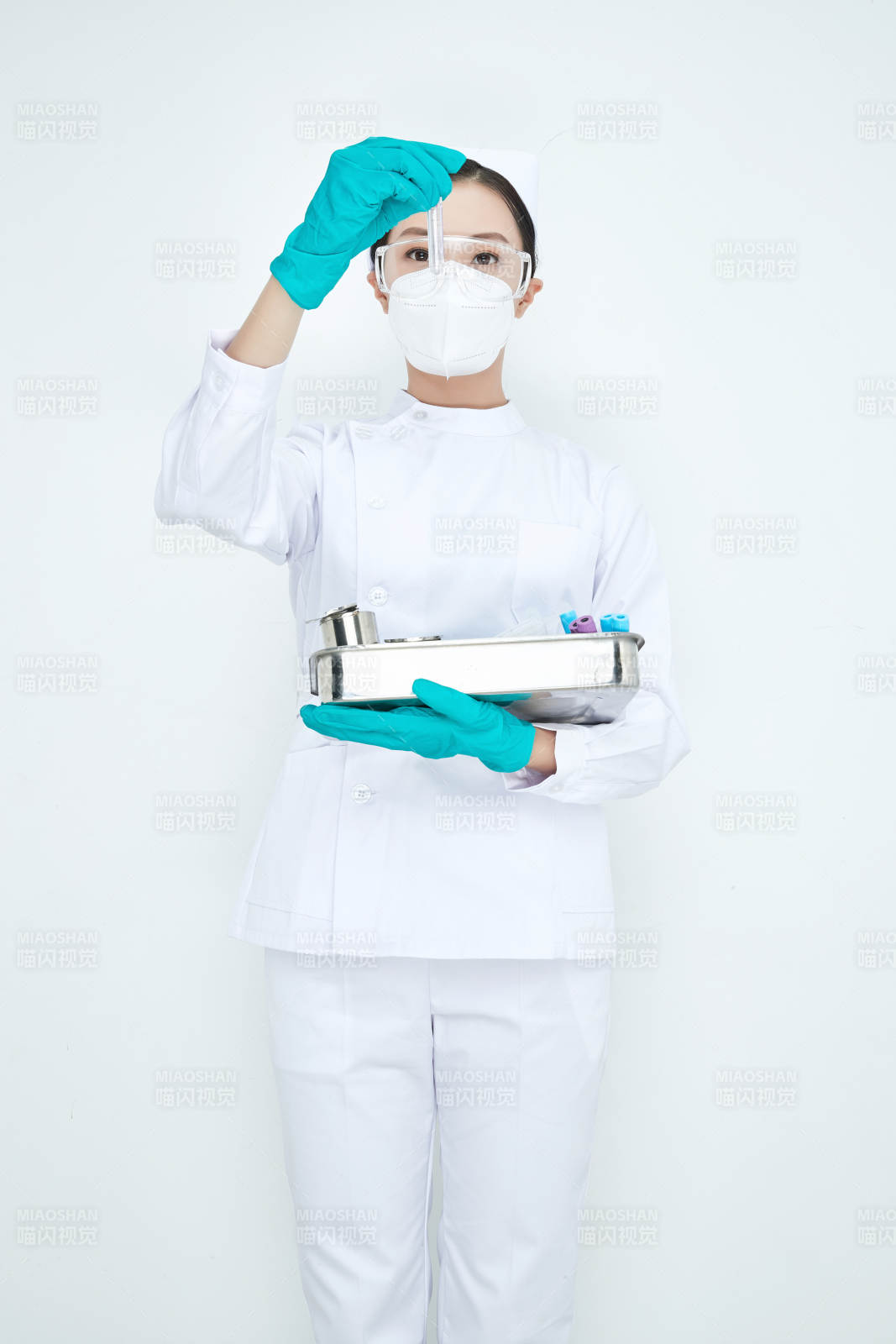 身穿護士服手抱化驗托盤的年輕女護士