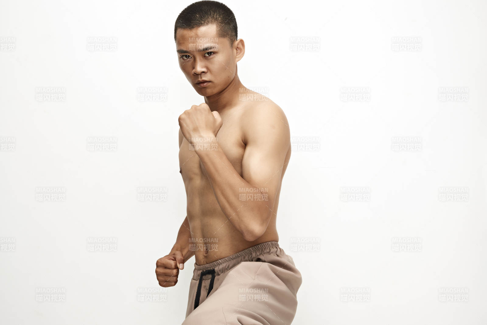 白色背景下演示自由搏擊動作的亞洲功夫男性