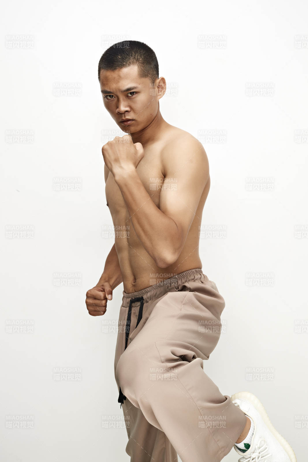 白色背景下演示自由搏擊動作的亞洲功夫男性