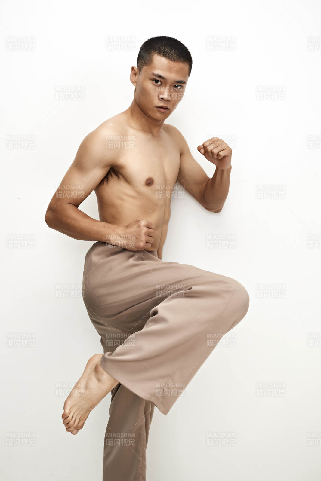 白色背景下演示自由搏擊動作的亞洲功夫男性