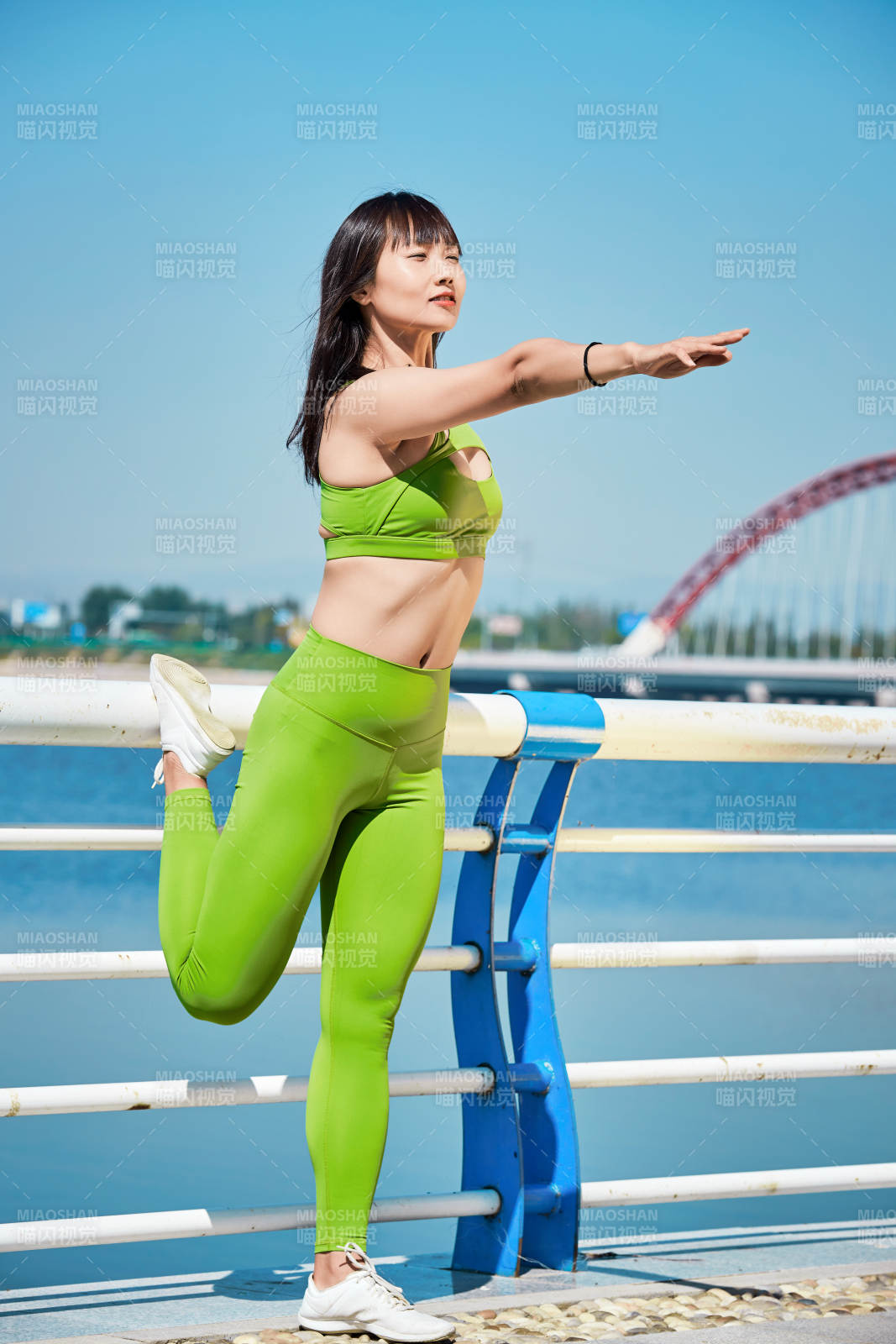 戶外河畔公園做拉伸有氧運動的亞洲女性