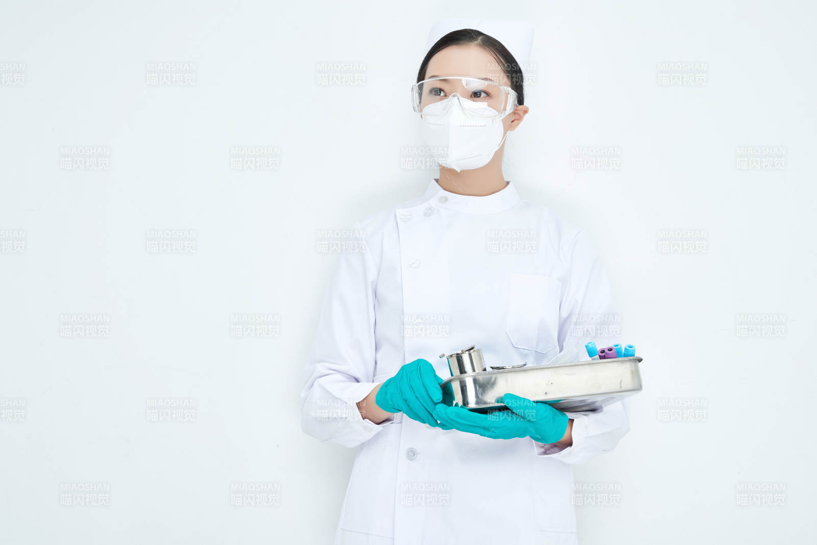 身穿護士服手抱化驗托盤的年輕女護士