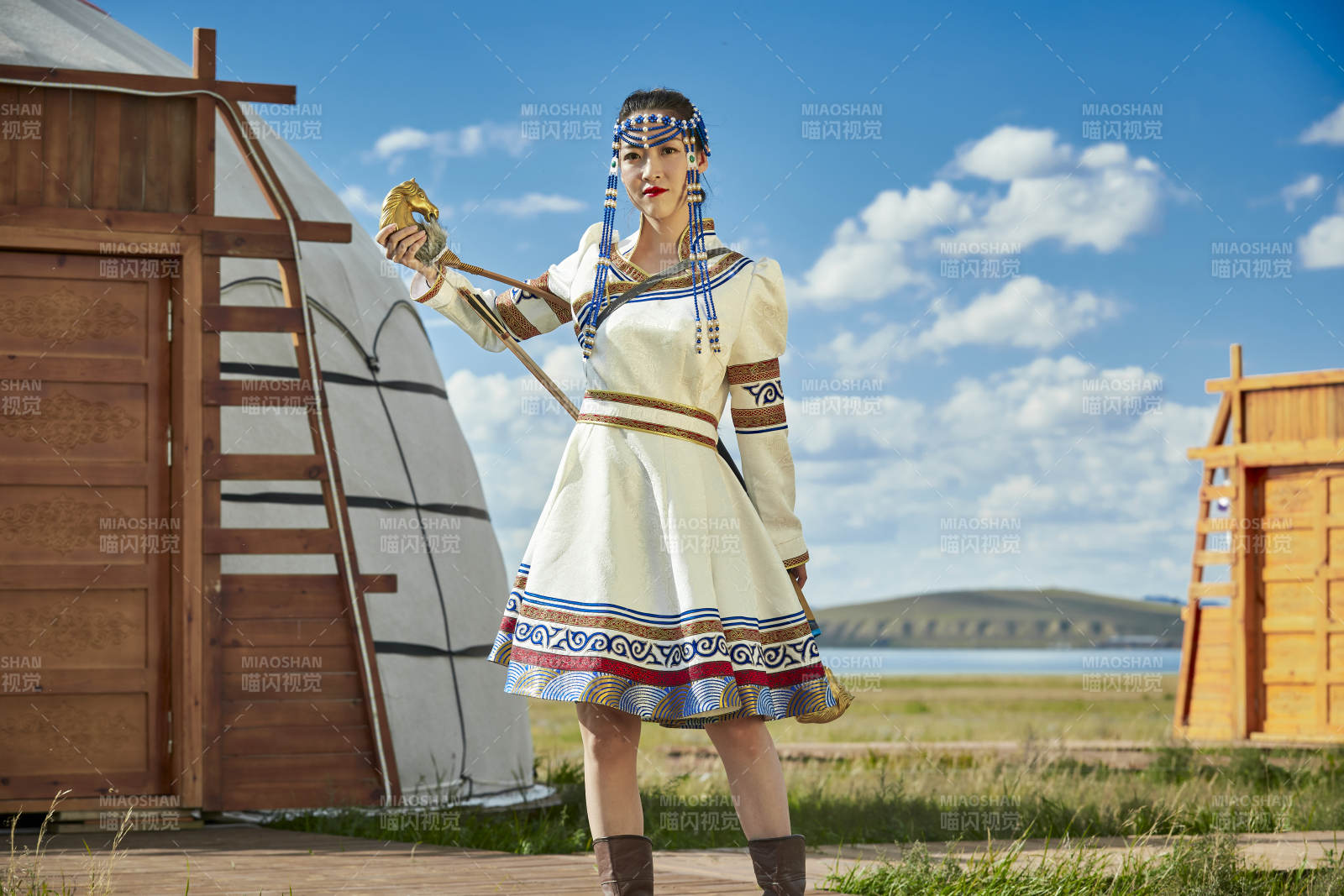 草原湖畔身穿蒙古族飾手持弓箭的蒙族少女