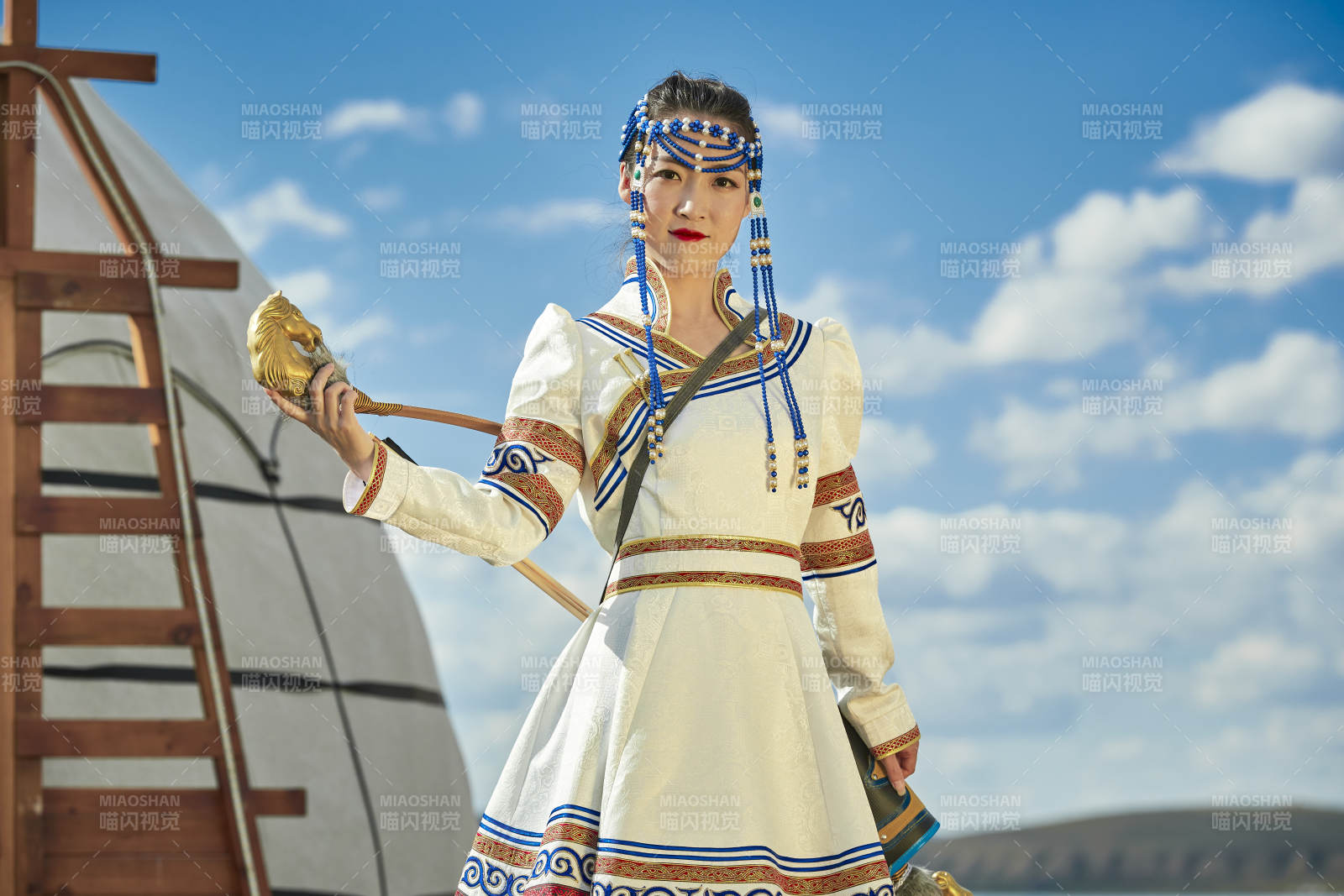 草原湖畔身穿蒙古族飾手持弓箭的蒙族少女