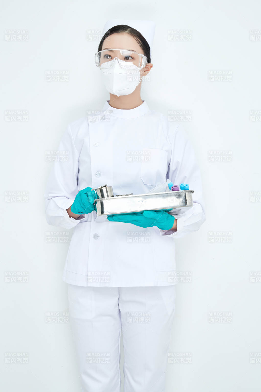 身穿護士服手抱化驗托盤的年輕女護士