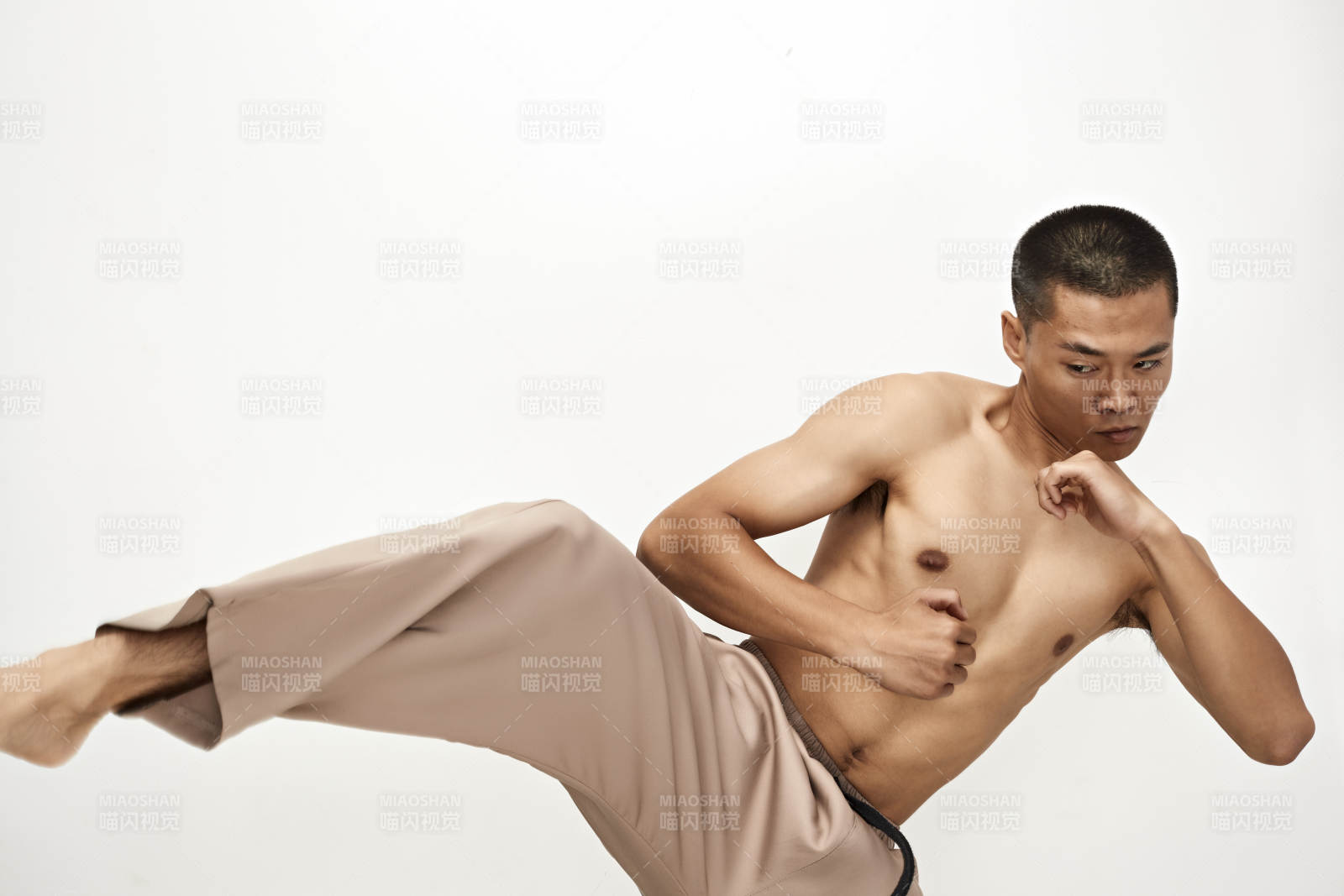 白色背景下演示自由搏擊動作的亞洲功夫男性